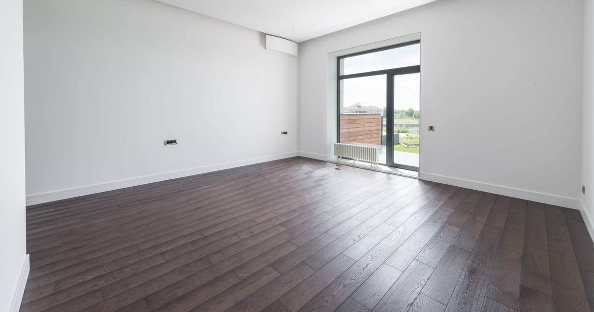 A freshly renovated apartment with new engineered-wood flooring and unopened furniture boxes.