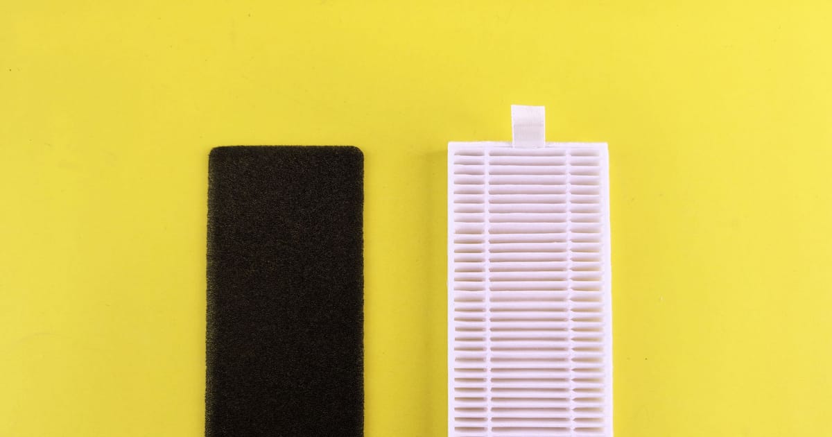 A pleated HEPA filter element lifted out of an air purifier housing.