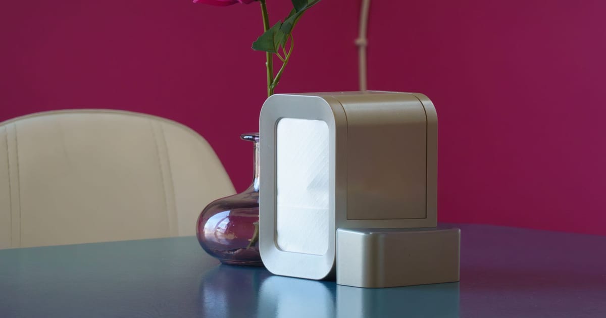 An air purifier standing clear of the wall in a living room, with a window behind it.