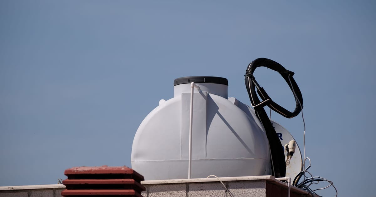 A wall-mounted purifier with a storage tank beside a slim under-sink tankless unit.