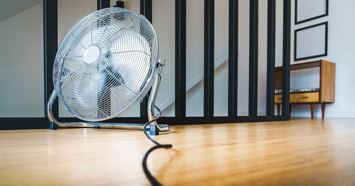 An air purifier standing on the floor away from furniture, with clear space on every side.